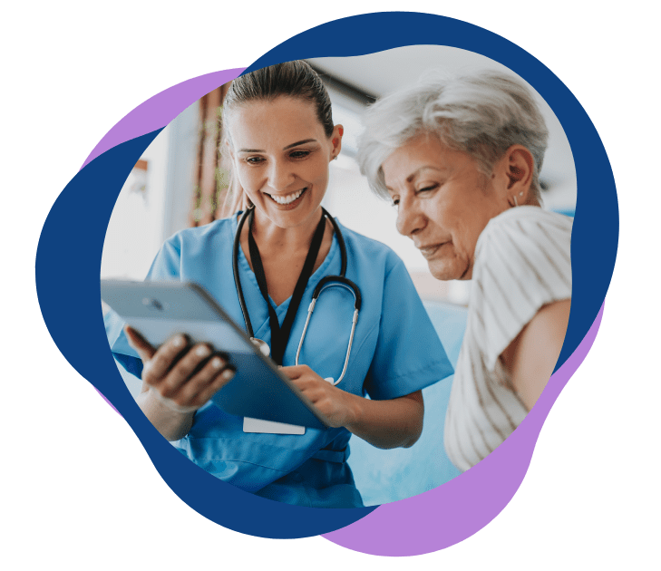 A nurse showing a tablet to an elderly woman, both smiling.