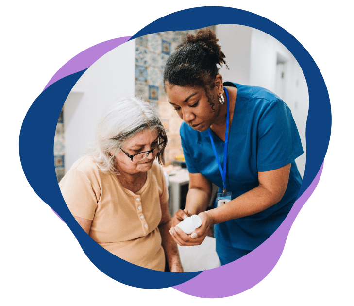 A healthcare worker assists an elderly woman with medication.
